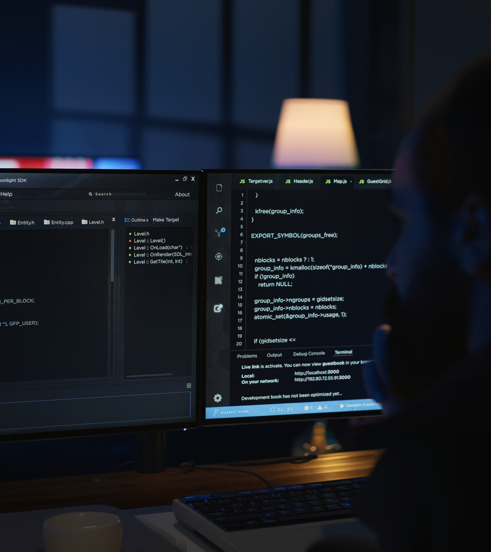 Developer workspace with dual monitors displaying code in a modern office